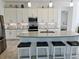 Bright kitchen features white cabinetry, stainless steel appliances, and an island with barstool seating at 585 Mosaic Blvd, Daytona Beach, FL 32124