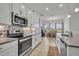 Well-lit kitchen has white cabinets, stainless appliances, decorative backsplash, and an adjacent dining area at 585 Mosaic Blvd, Daytona Beach, FL 32124