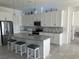 A modern kitchen features pendant lights, stainless steel appliances, stylish backsplash, and seating at the island at 585 Mosaic Blvd, Daytona Beach, FL 32124