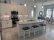 A modern kitchen is brightened by a tiled backsplash, pendant lighting and seating at the kitchen island at 585 Mosaic Blvd, Daytona Beach, FL 32124