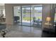 A covered patio, accessible through sliding glass doors, overlooks a serene pond, complete with seating and a grill at 585 Mosaic Blvd, Daytona Beach, FL 32124