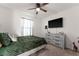 Comfortable bedroom featuring a ceiling fan, carpeted floor, and a modern dresser with TV at 650 Peyton Brooke Way, Winter Haven, FL 33881