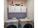 Functional laundry area with a stacked washer and dryer, cabinetry and decor at 650 Peyton Brooke Way, Winter Haven, FL 33881