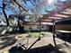 Backyard view showcases a pergola, lush foliage, and adjacent building at 7002 Rose Ave, Orlando, FL 32810