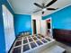 Bedroom with bright blue walls, a ceiling fan and two windows at 7002 Rose Ave, Orlando, FL 32810