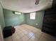 A secondary bedroom boasts tile floors, an AC unit and a window at 7002 Rose Ave, Orlando, FL 32810