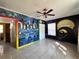 Unique bedroom with colorful mural, ceiling fan, and tiled flooring at 7002 Rose Ave, Orlando, FL 32810