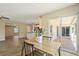 Bright dining area with wood-look tile and view to the outdoor patio and open-concept kitchen and living spaces at 7037 Edgeworth Dr, Orlando, FL 32819