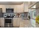 Close-up view of kitchen with stainless steel range, subway tile backsplash and granite countertops at 7037 Edgeworth Dr, Orlando, FL 32819