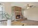 Comfortable living room featuring a brick fireplace, wood-look tile, and a ceiling fan for added comfort at 7037 Edgeworth Dr, Orlando, FL 32819