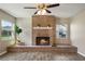 Inviting living room with a brick fireplace, wood-look tile flooring, and bright natural light from the windows at 7037 Edgeworth Dr, Orlando, FL 32819