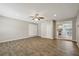 Open living room with wood-look tile flooring, featuring access to other rooms and natural light from windows at 7037 Edgeworth Dr, Orlando, FL 32819