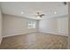 Spacious living room featuring wood-look tile flooring, neutral paint, and ample natural light from the windows at 7037 Edgeworth Dr, Orlando, FL 32819