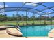 Screened-in pool and spa, offering a relaxing outdoor retreat with a view of the golf course at 7037 Edgeworth Dr, Orlando, FL 32819