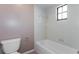 Bathroom featuring a toilet, a shower and tub combination with neutral tiling, and a small window at 7215 Scenic Pl, Lakeland, FL 33810