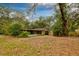 A property's rear exterior showcases a screened porch, shed, and spacious yard with mature trees at 7252 June Bug Ln, Orlando, FL 32818