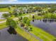 Scenic aerial view of a community featuring a lake, walking path, and recreational facilities surrounded by trees at 739 Spring Island Way, Orlando, FL 32828