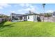 A sprawling green lawn and white home exterior with screened-in pool makes for a relaxing backyard setting at 739 Spring Island Way, Orlando, FL 32828