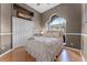 Well-lit bedroom features hardwood floors, arched window, closet, and light walls at 739 Spring Island Way, Orlando, FL 32828