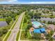 Aerial view of a community pool and playground area near a scenic lake and lush green landscape at 739 Spring Island Way, Orlando, FL 32828