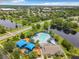 Aerial view showcases a community pool and playground near a scenic lake and lush greenery at 739 Spring Island Way, Orlando, FL 32828