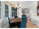 Charming dining area with a wood table, blue chairs, and natural light streaming through large windows at 739 Spring Island Way, Orlando, FL 32828