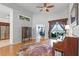 Bright living room with hardwood floors, a piano, access to the dining area, and sliding door to the outside at 739 Spring Island Way, Orlando, FL 32828