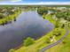 Overhead view of a serene lake with a walking path, enveloped by lush greenery and mature trees at 739 Spring Island Way, Orlando, FL 32828