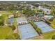 Aerial view of multiple tennis courts, basketball courts, pool, and playground near a lake in a green community at 739 Spring Island Way, Orlando, FL 32828