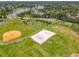 Aerial view of a sand volleyball court and baseball field in a lush, green community at 739 Spring Island Way, Orlando, FL 32828