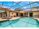 The serene pool is surrounded by an expansive screened-in patio and a charming tile roof at 8012 S Madeira Ct, Orlando, FL 32836