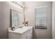 Bathroom with white cabinets, decorative mirror, and modern lighting fixture at 8012 S Madeira Ct, Orlando, FL 32836