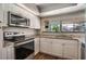 Modern kitchen featuring stainless steel appliances, granite countertops, and white cabinetry for a sleek look at 8012 S Madeira Ct, Orlando, FL 32836