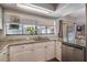 Bright kitchen featuring granite countertops, stainless steel dishwasher, and a view to the outside through the window at 8012 S Madeira Ct, Orlando, FL 32836