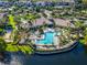 Aerial shot of the community pool, surrounding trees, and lake at 8323 Bella Vida Cir, Davenport, FL 33896