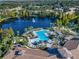 Beautiful aerial view of the community pool, lake, and lush landscaping at 8323 Bella Vida Cir, Davenport, FL 33896