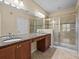 Bathroom featuring double sinks with granite countertops and modern glass shower at 8323 Bella Vida Cir, Davenport, FL 33896