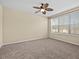 Comfortable bedroom with neutral color palette, ceiling fan, and lots of natural light from the window at 8323 Bella Vida Cir, Davenport, FL 33896