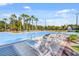 Beautiful community pool with comfortable lounge chairs and tropical landscaping at 8323 Bella Vida Cir, Davenport, FL 33896