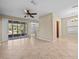 Spacious living room featuring tile flooring, a ceiling fan, and sliding glass doors to the lanai at 8323 Bella Vida Cir, Davenport, FL 33896