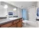 Cozy bathroom features a shower-tub combo with blue accents and a vanity with modern fixtures at 8712 Irmastone Way, Orlando, FL 32817