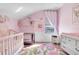 Bright and cozy baby bedroom with a pink rug and a crib near the window, creating a cheerful space at 8712 Irmastone Way, Orlando, FL 32817