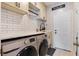 Well-lit laundry room with front-loading washer and dryer, sleek white countertops, and modern fixtures at 8712 Irmastone Way, Orlando, FL 32817