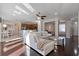 Spacious living room with hardwood floors, white sofas, and an open layout to the kitchen and dining area at 8712 Irmastone Way, Orlando, FL 32817