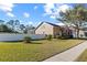 Side view of a well-maintained lawn with young palm trees and a white fence surrounding the property at 8712 Irmastone Way, Orlando, FL 32817