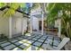 Backyard patio features unique tile and lawn block design, complemented by a grill and relaxing Adirondack chair at 909 E Central Blvd, Orlando, FL 32801