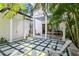 Inviting backyard patio features unique tile and lawn block design, complemented by a grill and relaxing Adirondack chair at 909 E Central Blvd, Orlando, FL 32801