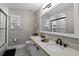 Modern bathroom featuring a dual sink vanity with black fixtures, a large mirror, and a tiled shower at 909 E Central Blvd, Orlando, FL 32801