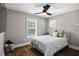 A cozy bedroom featuring wood floors, a ceiling fan, neutral walls, and natural lighting from two windows at 909 E Central Blvd, Orlando, FL 32801