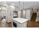 Open kitchen with stainless steel refrigerator, center island with microwave, and staircase leading to upper level of the home at 909 E Central Blvd, Orlando, FL 32801